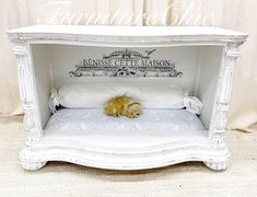 a small white bed with a yellow stuffed animal in it