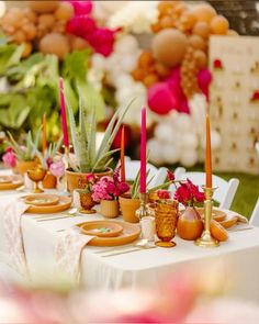 a table topped with lots of potted plants and candles