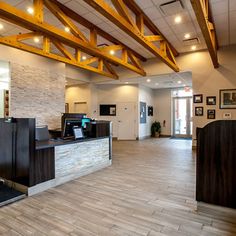 an empty lobby with wood floors and exposed beams on the ceiling is seen in this image