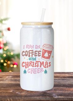 a white can with a straw in it sitting on a table next to a christmas tree