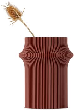 a red vase with a plant sticking out of it's center, on a white background