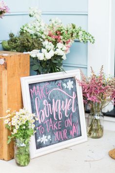 flowers are sitting in vases next to a sign