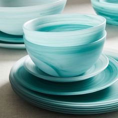 there are many blue bowls and plates on the table