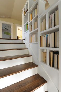 the bookshelves are lined up against the wall and on the stairs in front of the door