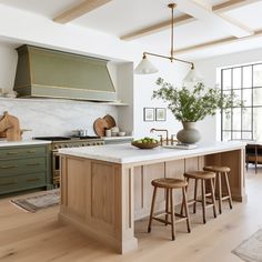 a kitchen island with stools in front of it and a potted plant on the counter