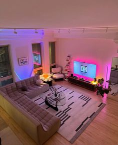 a living room filled with furniture and a flat screen tv sitting on top of a wooden floor