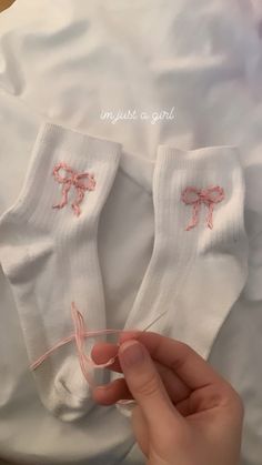 someone is stitching on their socks with pink thread