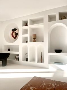 a living room with white walls and shelves filled with different types of objects on it