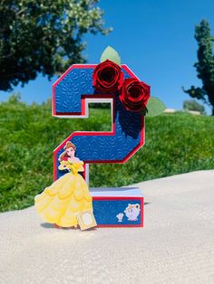 the letter e is made out of legos and has a princess figure next to it