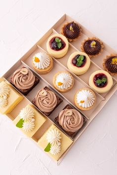 a box filled with lots of different types of desserts on top of a table