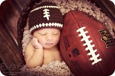 a baby is laying next to a football