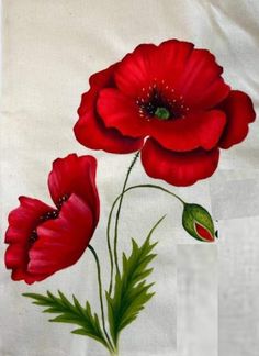 two red flowers on a white cloth with green leaves