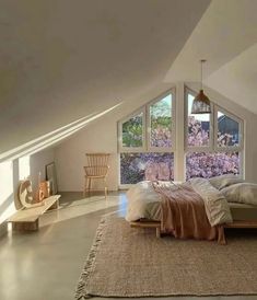 an attic bedroom with large windows and a bed in the middle, along with a rug on the floor