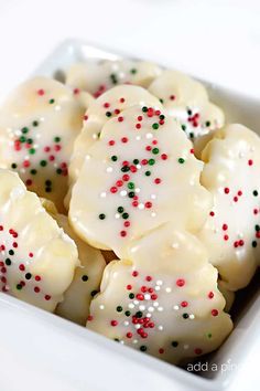 a white bowl filled with cookies covered in sprinkles