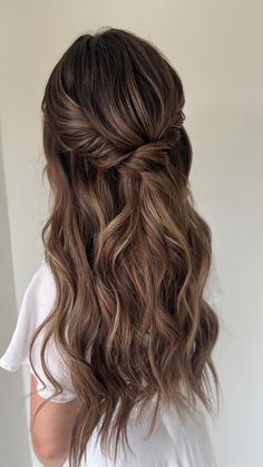 the back of a woman's head with long wavy hair in half - up style