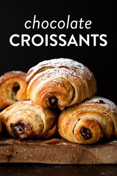 chocolate croissants piled on top of each other with powdered sugar in the middle