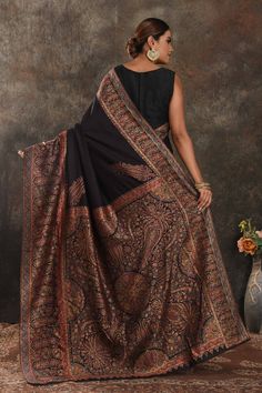 Exquisite black Kani weave tussar muga saree is one of a kind drape for a saree wardrobe! It comes with a matching blouse piece. Shop designer sarees in USA from Pure Elegance. The shown stitched blouse on the model is for display purpose only. The saree comes with a matching blouse piece and finished with fall and piko. Disclaimer: The actual product may vary slightly from the image. These are custom orders, hence expect slight variation in color, placement of the motif or buta. ESTIMATED DELIVERYBecause this is a custom order, it would take about 4 weeks from the date of purchase. RETURN POLICYThis product is a custom order and cannot be returned or exchanged. Latest Silk Sarees, Tussar Silk Sarees, Latest Designer Sarees, Fashion Journals, Pure Elegance, Black Saree, Desi Girl, Tussar Silk Saree, Indian Saree