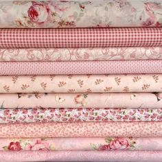 a stack of pink and white fabric with roses on them, all in different colors