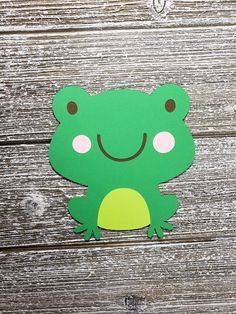 a green frog cut out on top of a wooden table