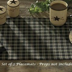 three mugs sitting on top of a table next to a fork and cup filled with coffee