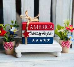 an american land of the free sign with potted flowers