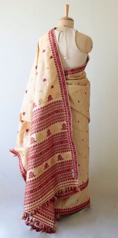 This is a Handloom, Hundred Percent Pure Tassar  Silk Saree from the looms of ASSAM. Tassar Silk -  The Tassar Silk moth is basically a wild moth. Hence it is categorised as Vanya Silk or Wild silk by the silk board of India.(http://csb.gov.in/silk-sericulture/silk/vanya-silk/).  The yarn produces is a natural brownish or off white  colour. Tassah silks in their natural colour can be termed as Organic Silk as no chemicals have been used in the cultivation of host trees or in the processing of silk fabrics.. Most Tassar rearing and cultivation is still done by village clusters in the tribal regions of Jharkhand ,Chattisgarh & West Bengal   in the traditional method. In this case , the yarns have been dyed .  The motifs and designs are very traditional . The motifs are in Acrylic yarns .  Th Assam Silk Saree, Silk Moth, Off White Colour, Bandhani Dress, Cotton Saree Designs, Silk Sari, Saree Dress, Traditional Sarees, White Colour