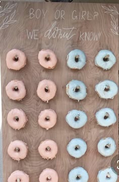 doughnuts are arranged on a wooden board with words written on the back ground