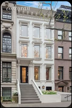 this is an image of a two story house with stairs leading up to the front door