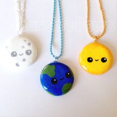 three necklaces with different designs on them, one is blue and the other is yellow