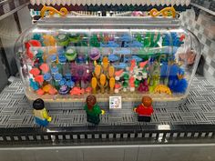 a display case filled with lots of different colored plastic toys on top of a counter