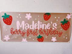 a sign that says madeline's berry first birthday with strawberries on it