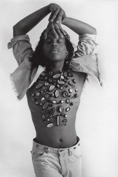 a black and white photo of a woman with her hands on her head while wearing jewelry