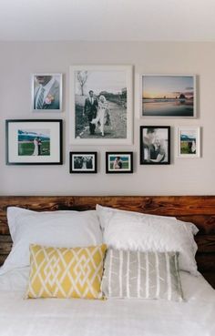 a white bed topped with lots of pictures on the wall above it's headboard