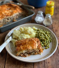 sausage and onion puff pastry pie on a plate with peas