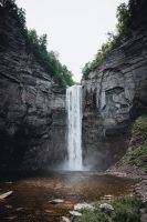 there is a waterfall in the middle of some rocks and water flowing down it's sides