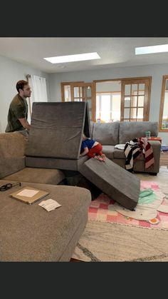 a man standing in the middle of a living room filled with couches and furniture