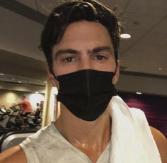 a man wearing a black face mask in a gym