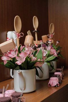 a bunch of spoons are sitting on a table with flowers in the vase and other items