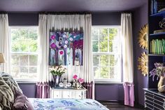 a bedroom with purple walls and white curtains