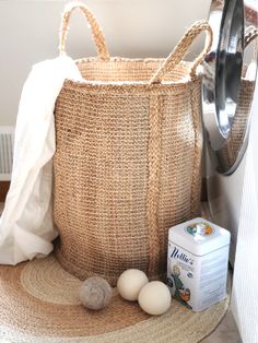 a laundry basket sitting on the floor next to a dryer and other items in front of it