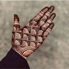 the hand is decorated with henna designs on it's palm, and there is no image to describe