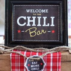 a sign that says welcome to the chilli bar on top of a wooden box