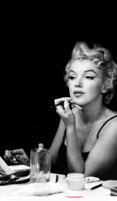 a black and white photo of a woman sitting at a table