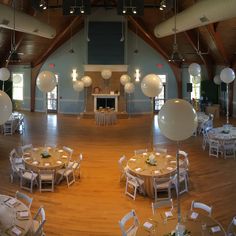 an empty banquet hall with tables and white balloons