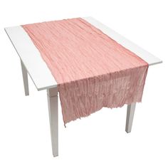 a pink and white table cloth on top of a wooden table