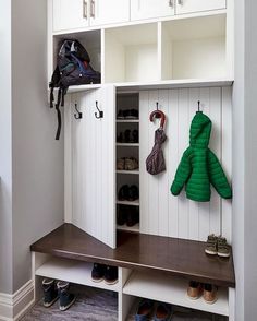 a coat rack with two coats hanging on it's sides and some shoes underneath