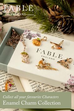 an open box with charms on it and the words fable england next to it