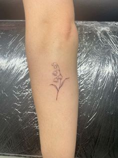 a woman's foot with a small flower tattoo on her left calfocks and the word love written in cursive writing