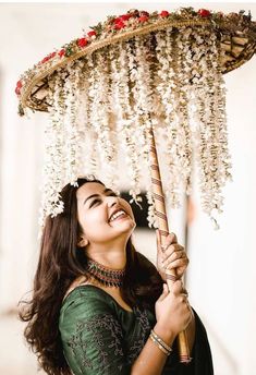 a woman is smiling while holding an umbrella