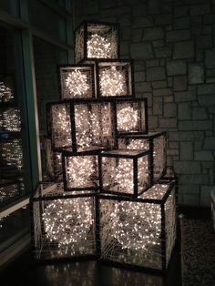 lighted cubes stacked on top of each other in front of a window at night